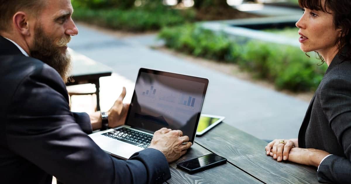 Dva poslovna partnera pregledaju podatke o firmi na laptopu Dva poslovna partnera pregledaju podatke o firmi na laptopu